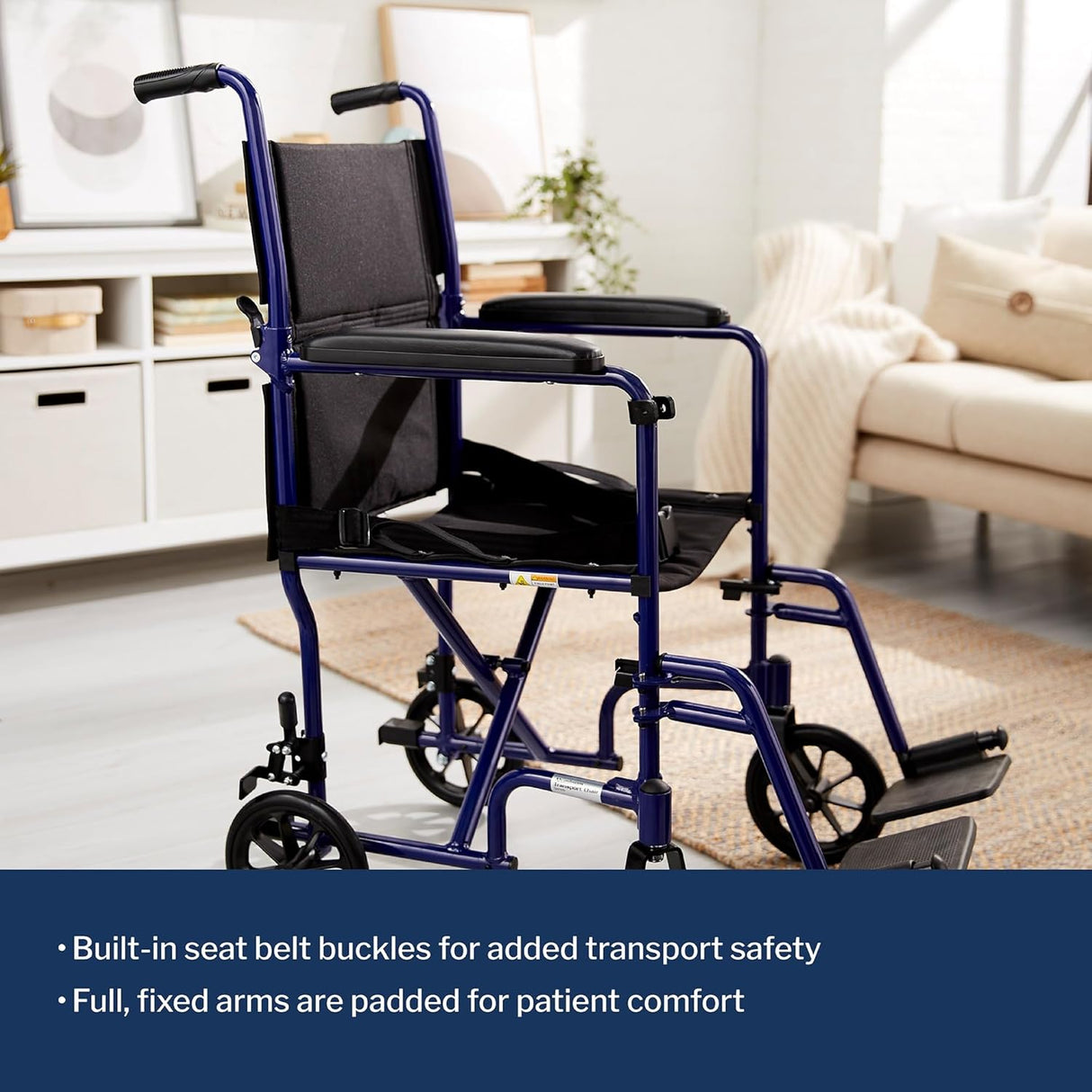 A blue McKesson Lightweight Aluminum Transport Chair with black seat, backrest, fixed armrests, and footrests is in a bright living room. Text highlights its built-in seat belt buckles and padded, fixed arms for comfort and safety.