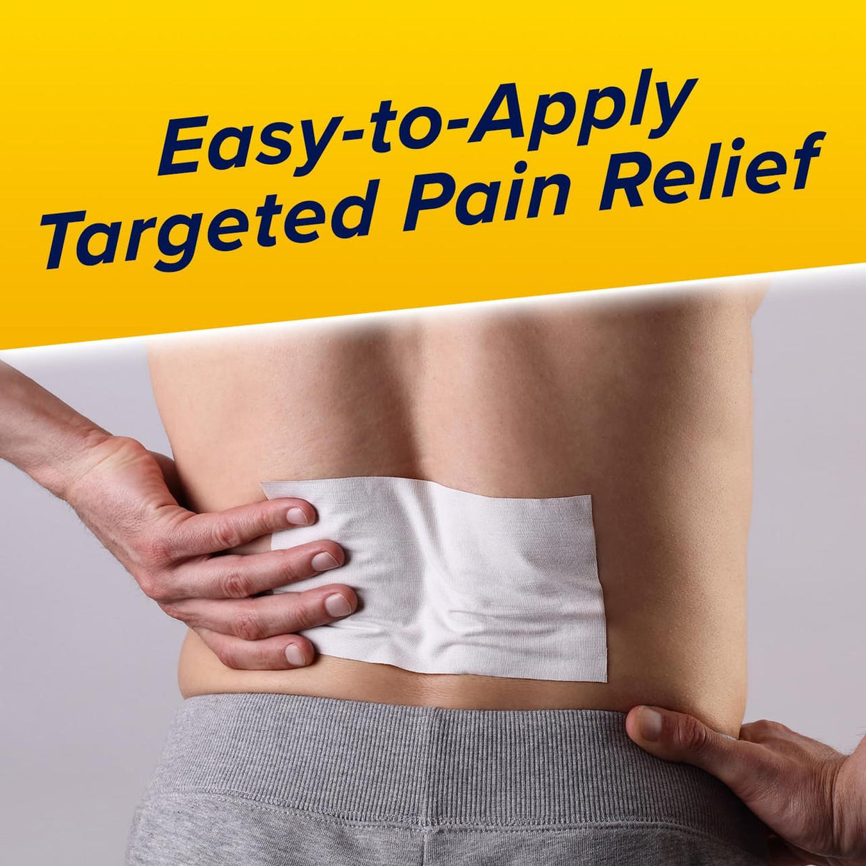 Someone applies an Aspercreme Max Strength Lidocaine Pain Relief Patch to their lower back, with Easy-to-Apply Targeted Pain Relief written above on a yellow background.