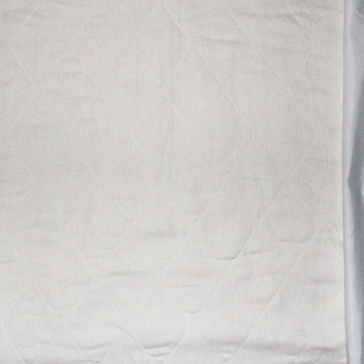 A close-up of Becks Classic Birdseye Reusable Underpad with a pink backsheet, heavy absorbency, and a subtle diamond quilted pattern with soft horizontal creases.