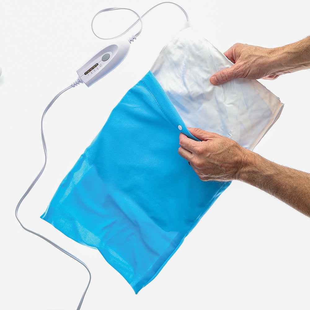 A person holds the BodyMed LED Moist & Dry Heating Pad with a white controller and blue cover, showing the pad partially out against a white background—ideal for soothing muscle strain.