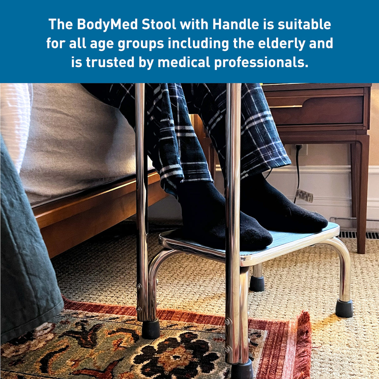 An elderly person in plaid pajama pants and black socks stands on the BodyMed Step Stool with Handle by BodyMed next to a bed. Text above highlights its safety for all ages and trust by medical professionals.