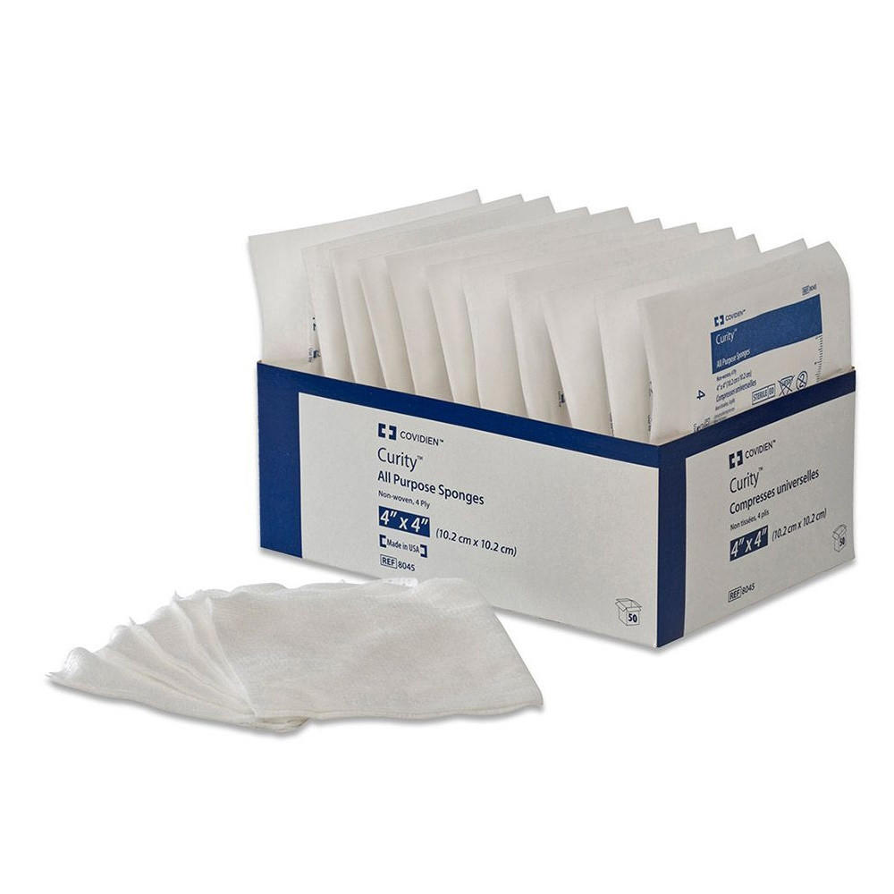 A box of Covidien Dermacea Sterile Non-Woven Sponge, 4-ply square. Several individually packaged gauze pads are displayed in front of the box, along with some opened white sponges.