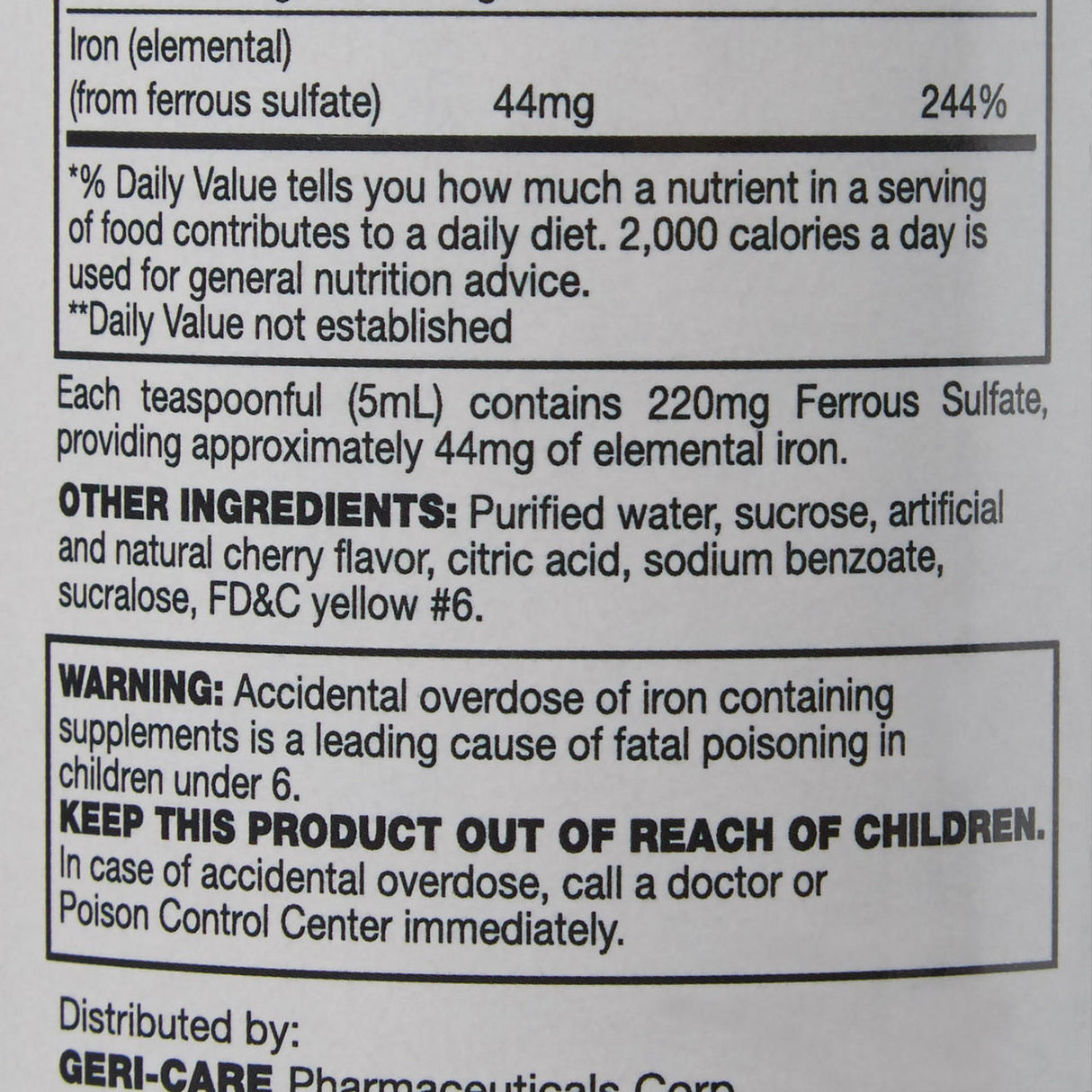 Close-up of a McKesson Geri-Care Iron Supplement 220 mg Elixir label, displaying supplement facts, dosage, ingredients, overdose warning, and child safety advice; bottle size is 16 oz.
