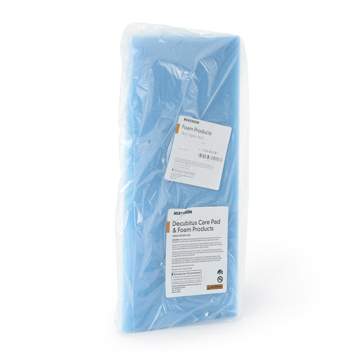 The McKesson Positioning Wedge, 8 W x 18 D x 8 H, is a light blue medical-grade polyurethane foam block sealed in clear plastic with two white labels for comfort support and patient positioning.