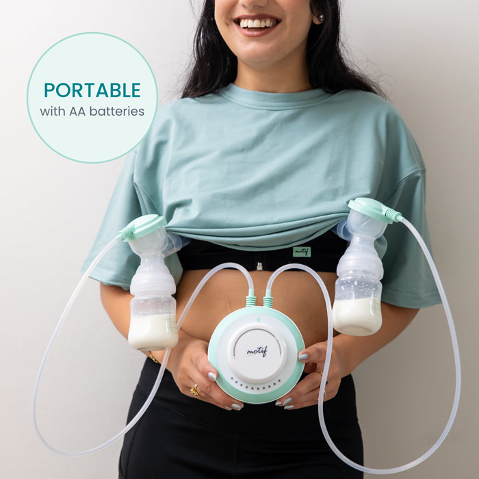 A smiling woman uses the Motif Twist Double Electric Breast Pump, with two bottles attached to her chest. She holds the main control unit. Text reads: PORTABLE breast pump with hospital-strength suction and AA batteries by Motif.