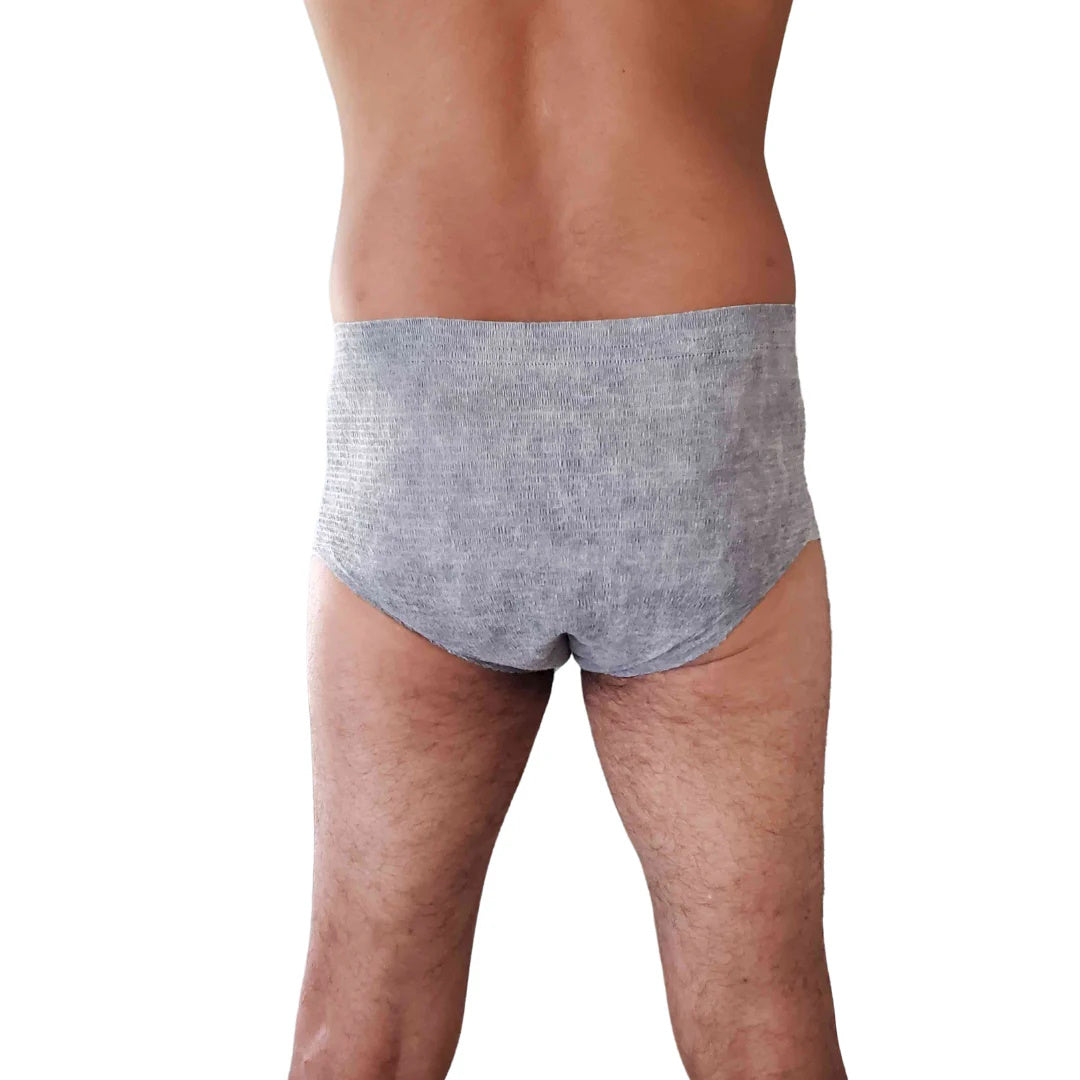 A person is shown from the waist down, standing and wearing Nexwear Mens Incontinence Underwear in gray, photographed from the back against a white background.