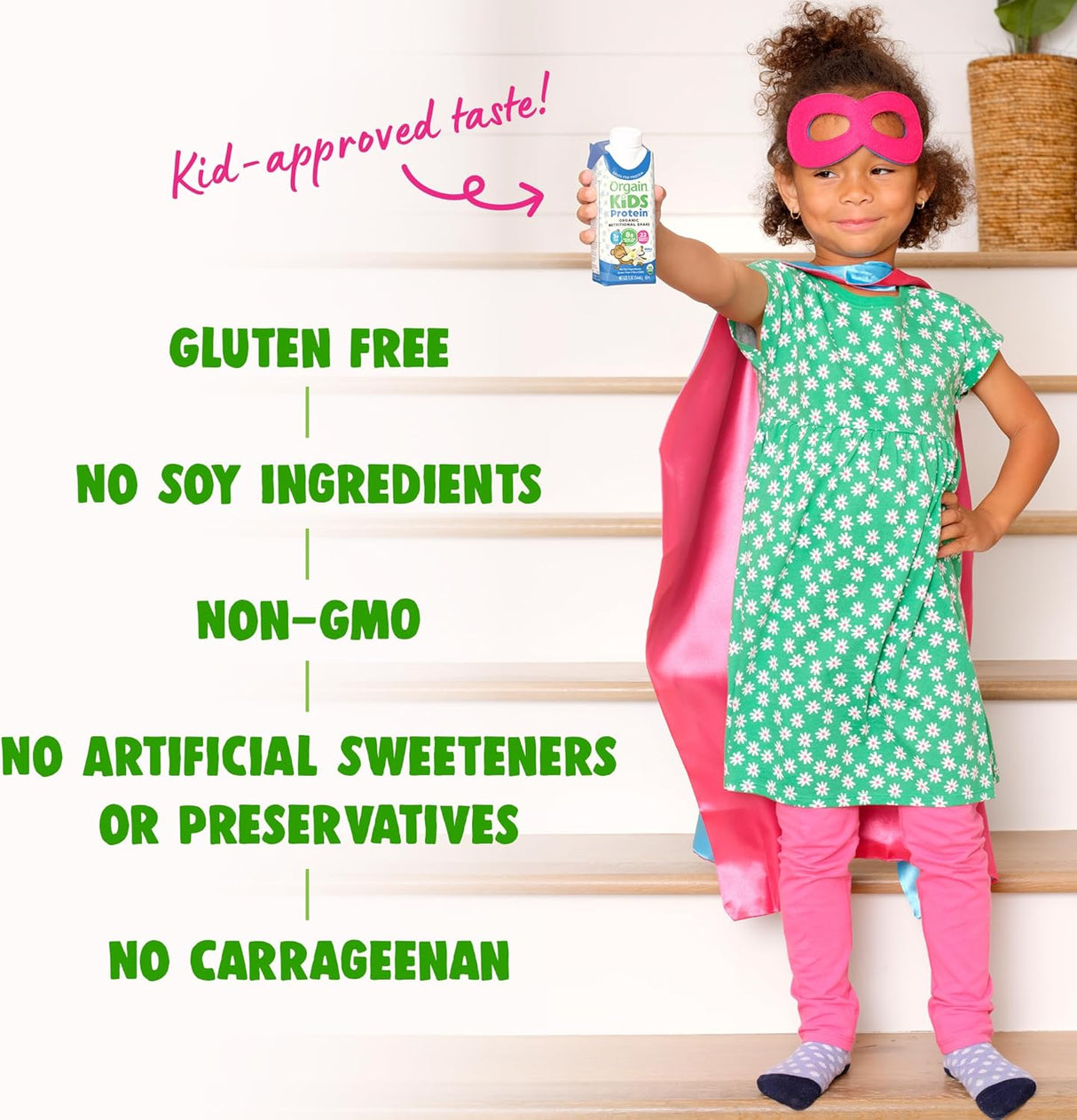 A young girl in a superhero costume holds an Orgain Organic Kids Nutritional Grass-Fed Protein Shake, Vanilla. Text highlights its gluten free, non-GMO, with no soy ingredients, artificial sweeteners or preservatives, and no carrageenan.