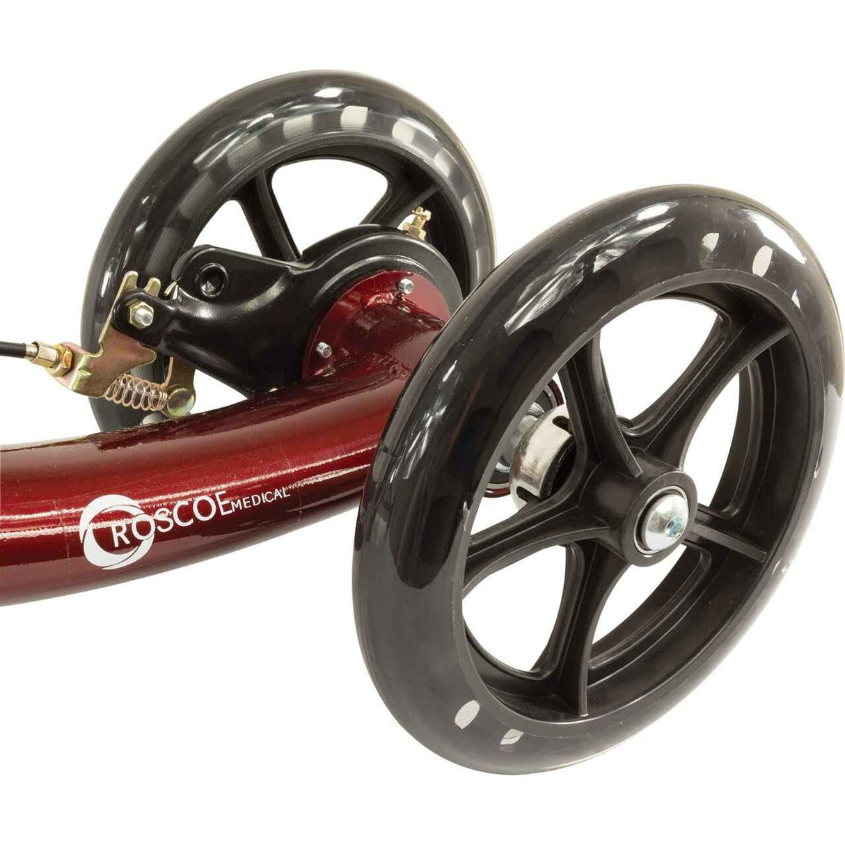 Close-up of two large black wheels on a curved red frame labeled Roscoe Medical, part of the Roscoe Deluxe Knee Scooter by Roscoe Medical.