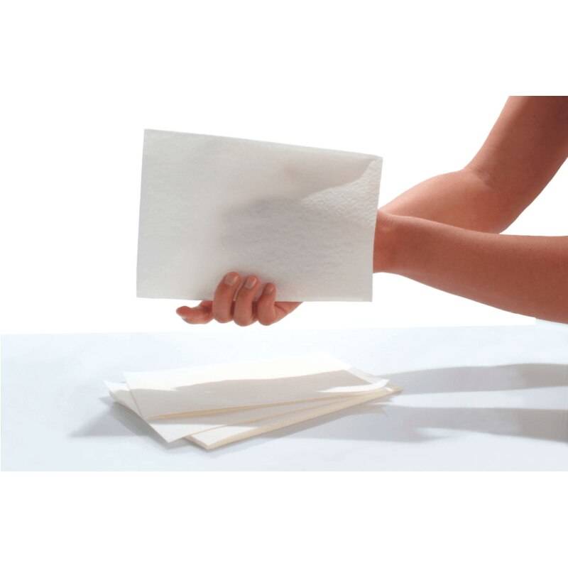 A hand holds a single Seni Care Personal Care Glove by Seni above a surface with a small stack of similar gloves, evoking no-rinse cleansing. The background is plain and well-lit.