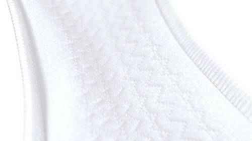 Close-up of the white textured fabric on TENA ProSkin Pads Heavy by TENA, showing a subtle zigzag pattern and neatly sewn edges. The soft, padded surface is designed for women’s incontinence protection.