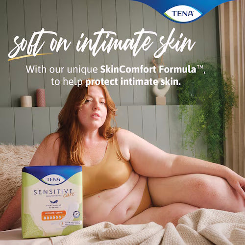 A woman in beige underwear sits on a bed beside a box of TENA Sensitive Care Incontinence Pads, Ultimate. Text reads: Soft on intimate skin with our unique SkinComfort Formula™ for gentle bladder leakage protection.