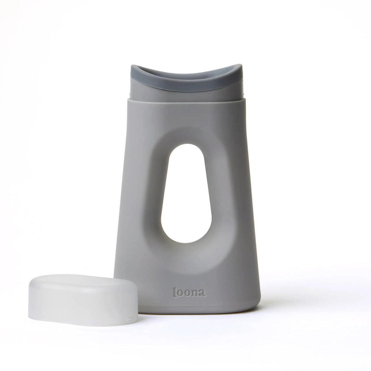 The Loona Female Urinal With Closure by Boom Home Medical is a modern gray plastic travel urinal with a curved, ergonomic design, an oval center cutout, and the word loona embossed at the bottom. The closure cap is shown placed beside it.