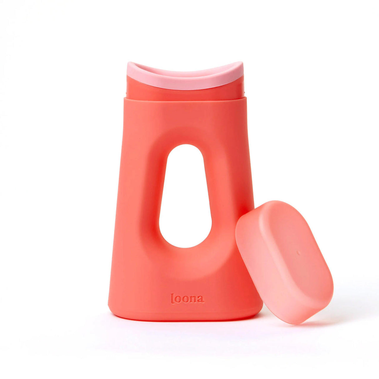 The Loona Female Urinal With Closure by Boom Home Medical is a modern coral pink urinal for women, featuring a large oval cutout, matching removable cap, and discreet branding—ideal as a stylish bedside or travel urinal.
