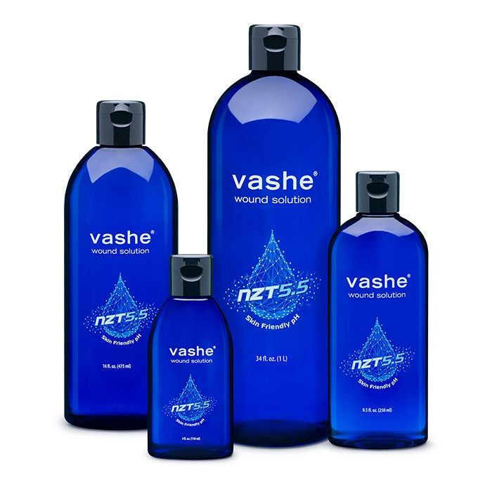 Four blue bottles of URGO Medical Vashe Wound Cleanser, each with a dark cap and white text displaying NZT 5.5 Skin Friendly pH, are shown in various sizes.