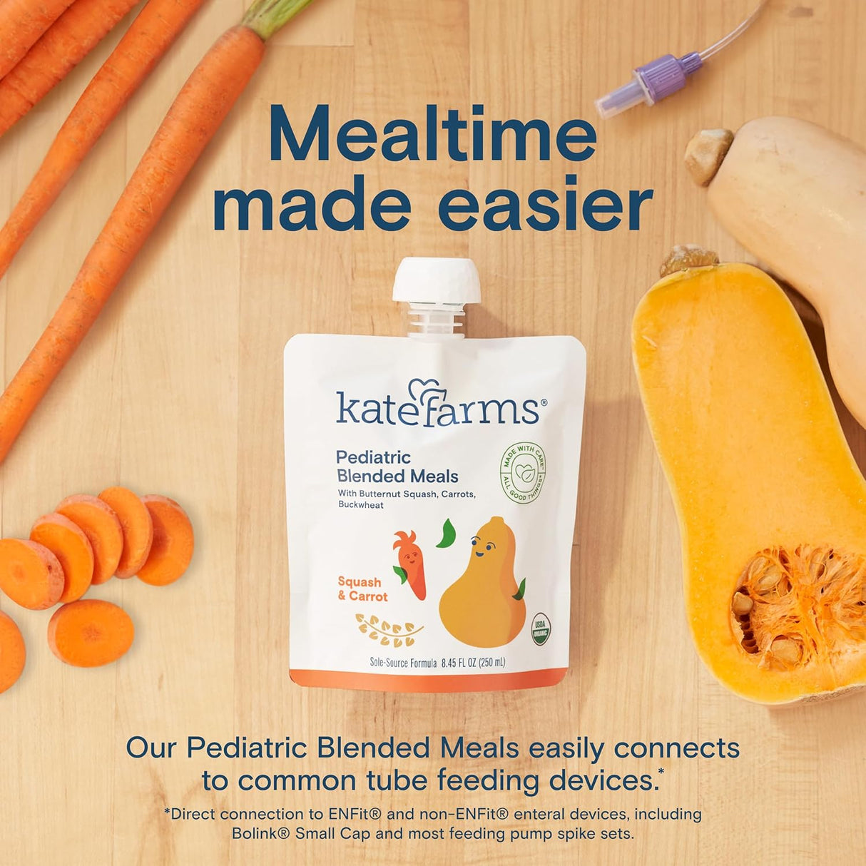 A pouch of Kate Farms Pediatric Blended Meals, Squash & Carrot, CS/12 sits on a wooden surface with fresh carrots, butternut squash, and a feeding tube. Text: "Mealtime made easier with plant-based nutrition—tube feeding compatible.